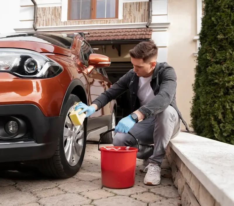 Lavage auto à domicile Étival-Clairefontaine : professionnel intervenant sur un véhicule